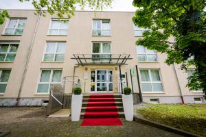 波恩Aparthotel Alma Bonn的前面有红地毯的建筑