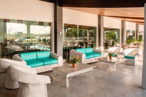 卡鲁阿鲁帕里姆卡鲁阿鲁村酒店的带沙发和桌椅的天井。