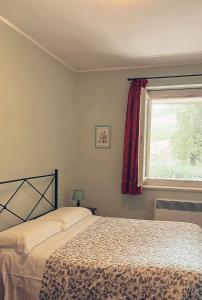 Collazzone阿尔伯拉塔乡村民宿的一间卧室设有一张床和一个窗口
