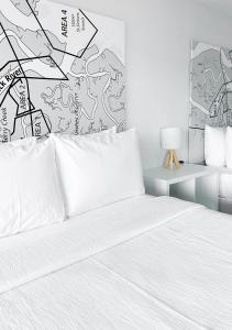 布伦瑞克Oneway Brunswick的一间卧室配有一张带白色床单和一盏灯的床。