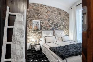 波托菲诺Portofino Luxury Front Marina by PortofinoVip的一间卧室设有一张床和砖墙