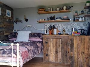 赫尔斯顿Rhubarb Hut, set in the beautiful Cornish Countryside的一间卧室配有一张床和一个木制橱柜