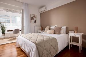 雅典Elaia Luxury Selections Opal的卧室配有一张白色大床和一张书桌