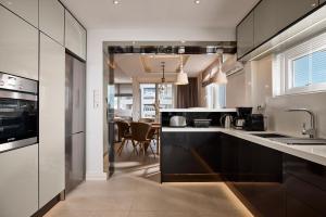 雅典Elaia Luxury Selections Opal的厨房配有黑白橱柜和桌子