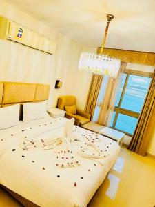 阿可贺巴شاليهات ويف -Wave Resort的卧室配有一张带吊灯的大型白色床。