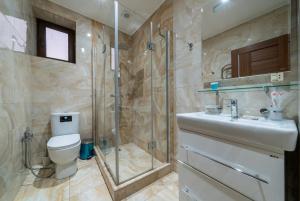 迪利然Aurora Villas的带淋浴、卫生间和盥洗盆的浴室