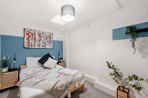 布里斯托Lovely Bristol Gem - Sleeps 24的卧室配有一张床,墙上挂有绘画作品