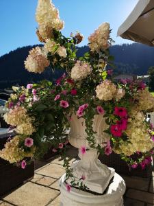 基茨比厄尔附近赖特Hotel Garni Zimmermann的阳台上的白色花瓶装满鲜花