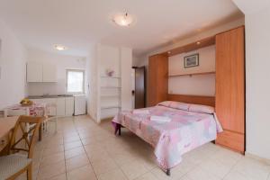 卡波利韦里Villino nel Bosco的一间卧室配有一张床铺和一张桌子,还设有一间厨房