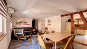 埃圭斯海姆Le Nature d'Eguisheim的用餐室以及带桌椅的起居室。