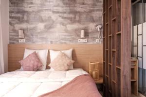 马雷讷INSPIRE Villages - Marennes Oléron的一间卧室配有带白色床单和粉红色枕头的床。