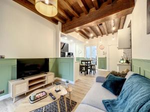 特鲁瓦Les Terrasses du Bouchon的带沙发和电视的客厅