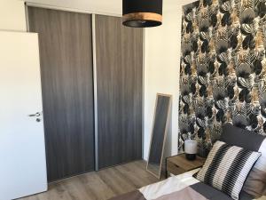 弗龙蒂尼昂Appartement en bord de plage serviettes non incluses的一间卧室设有一张床和一面墙