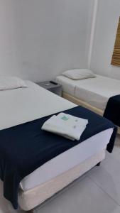 亚松森Casa de Mia的一间设有两张床和床上毛巾的房间