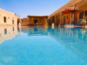 梅尔祖卡Riad Hotel Les Flamants的大楼前的游泳池