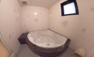 名古屋酒店.COM（仅限成人）的带窗户的浴室设有大浴缸