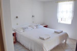 诺瓦利娅TEODORA - kamenný domek 300 m od moře的白色卧室配有带2条毛巾的床