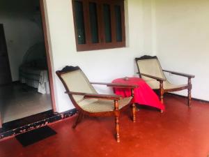 本托塔荷马旦酒店的房间里的两张椅子和一张红色桌子