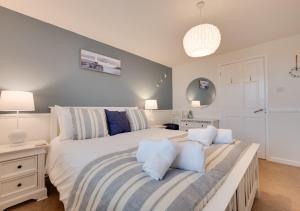 森嫩Flora Belle Cottage的卧室配有带蓝色枕头的大型白色床