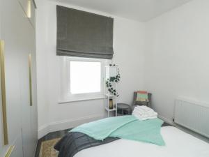 埃克塞特The Annex的一间卧室设有一张床和一扇窗户,窗户遮荫