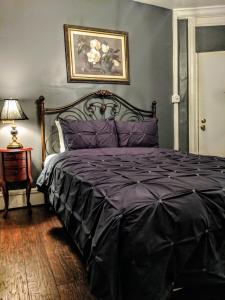 大西洋城Chelsea Pub and Inn的一间卧室配有一张带紫色棉被的床