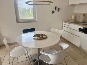 圣维托诺曼Casa Eva的厨房里配有白色的桌椅