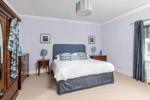 LaurencekirkThe Cowshed的一间卧室配有一张蓝色床头板的床