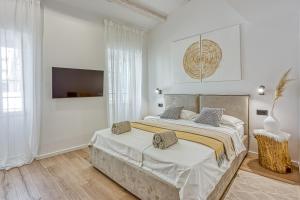 罗维尼La Pelegrina的一间白色卧室,配有一张大床和一台电视