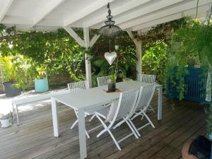 圣吕斯Villa Cocon Bleu , plage à pied !的木制甲板上的白色桌子和椅子