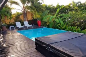 圣吕斯Villa Cocon Bleu , plage à pied !的游泳池旁设有两把白色椅子