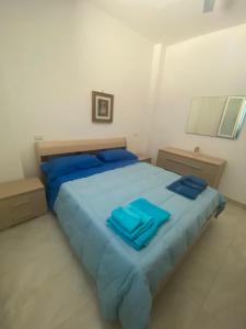 圣伊西多罗Casa Vacanza La Torre的一间卧室配有蓝色大床和蓝色枕头