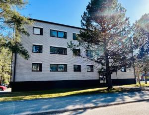 凯乌鲁Tilava huoneisto Keuruun keskustassa的前面有棵树的白色建筑