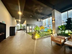 吉隆坡Millennium Suite At Opus Residence的办公室大厅设有长椅和植物,窗户