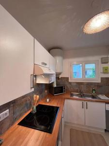 圣马克西姆Grand appartement a 300M de la plage的厨房配有白色橱柜和炉灶烤箱。