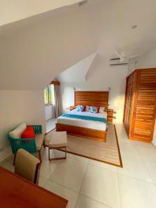 马埃岛Nautilus Apartments的一间卧室配有一张床、一张沙发和一把椅子