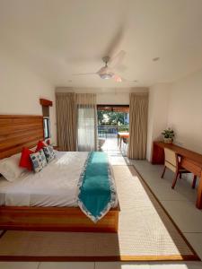 马埃岛Nautilus Apartments的一间卧室配有一张大床和一张书桌