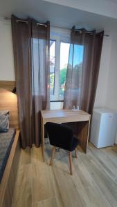 奥赫里德Villa Natali的卧室配有书桌和椅子,位于窗户前