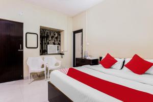 贾姆谢德布尔OYO Flagship Hotel Jagbamda的一间卧室配有一张带红色枕头的大床