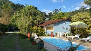 特雷索波利斯Pousada Jardim Secreto的蓝色的房子,在院子里设有一个游泳池