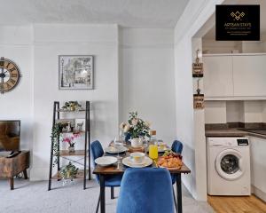 滨海绍森德Deluxe Apartment in Southend-On-Sea by Artisan Stays I Free Parking I Perfect for Contractors or Families的一间带桌子和蓝色椅子的用餐室