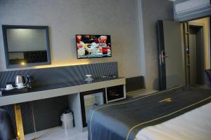安卡拉阿尔芬酒店的酒店客房设有一张床和墙上的电视