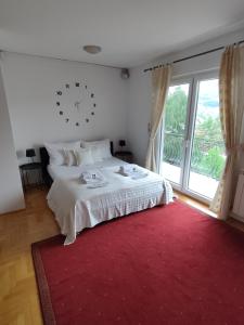萨拉热窝Villa Kuna的卧室配有白色的床和红色地毯。