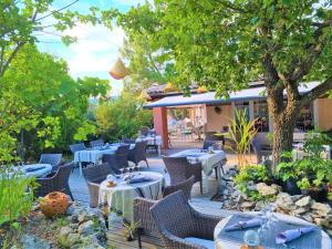 萨路特德沃克吕兹Domaine du Val de Sault的一个带桌椅的庭院和一间餐厅