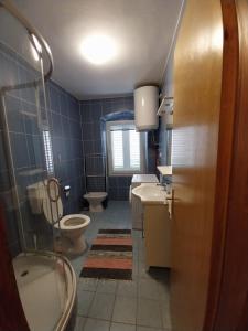 木洛希尼Apartmani Jadran的浴室配有卫生间、盥洗盆和浴缸。