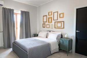 Castel CampagnanoDimora Musco Bed & Breakfast的一间白色的卧室,配有一张床和墙上的一些照片