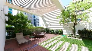 MakkasanCitiresort Living sukhumvit 39的一个带椅子和树的户外庭院