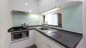 MakkasanCitiresort Living sukhumvit 39的白色的厨房配有水槽和微波炉