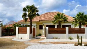 棕榈滩Endless Summer的一座带围栏和棕榈树的房子