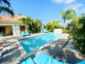 棕榈滩Endless Summer的棕榈树屋前的游泳池