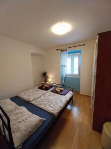 木洛希尼Apartmani Jadran的一间卧室设有两张床和窗户。